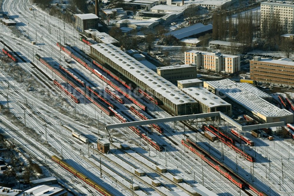 Berlin from the bird's eye view: Wintry snowy terrain railway depot and repair shop for maintenance and repair of trains of passenger transport destrict Lichtenberg in Berlin in Germany