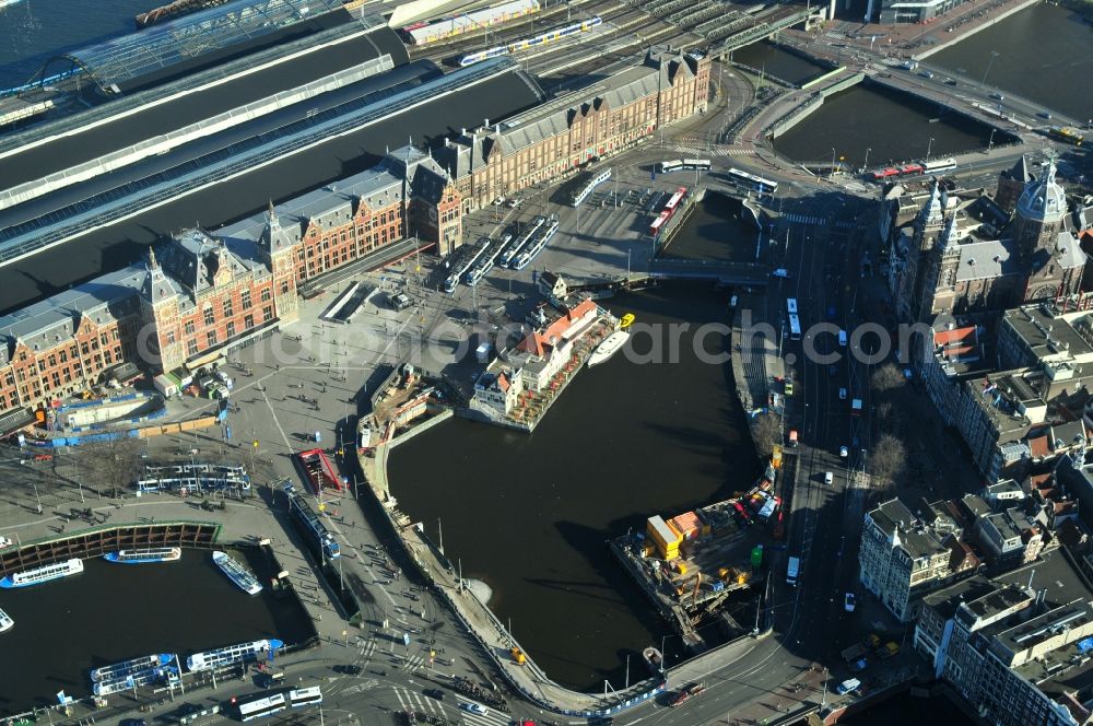 Aerial photograph Amsterdam - View of the station Amsterdam Centraal at the Open Havenfront in Amsterdam in the province of North Holland in the Netherlands. Nearby the station is the Basiliek Van de H. Nicolaas located