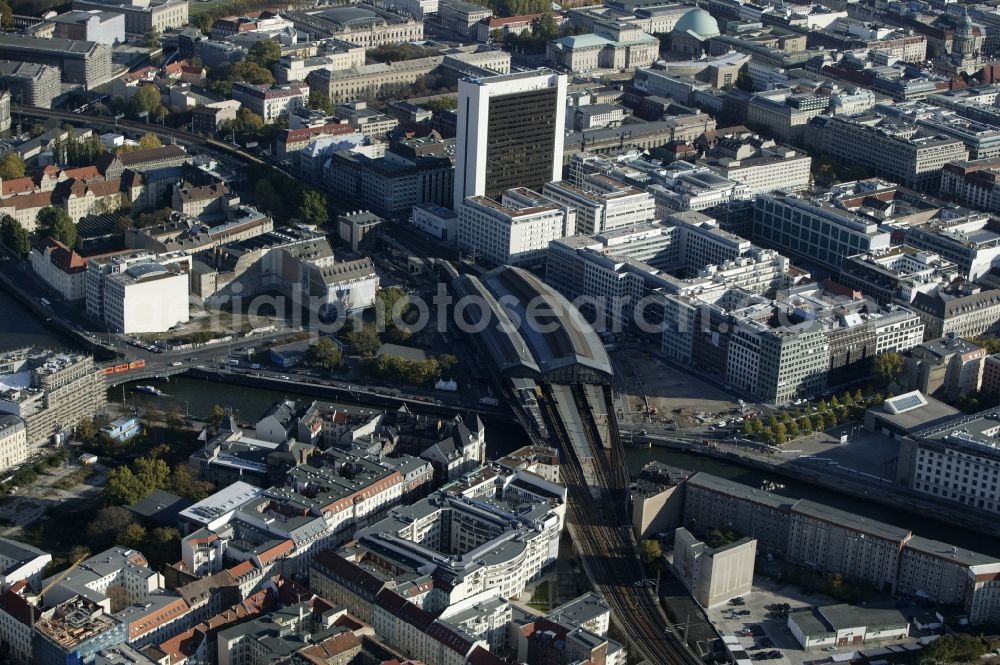 Aerial image Berlin - The Friedrichstrasse station in Berlin Germany Berlin surrounded by modern residential and commercial buildings in the eastern city of the capital. The Friedrichstrasse railway station is a major transportation hub for local and long-distance transport in the city. About a brigde the tracks run over the Spree. On Friedrichstrasse is the International Trade Centre, an office building, in which many prominent companies such as Adam Opel AG and RWE are established. At the intersection Dorotheenstrasse the Maritim hotel is located. In the background the Pergamon Museum and the St. Hedwig's Cathedral can be seen