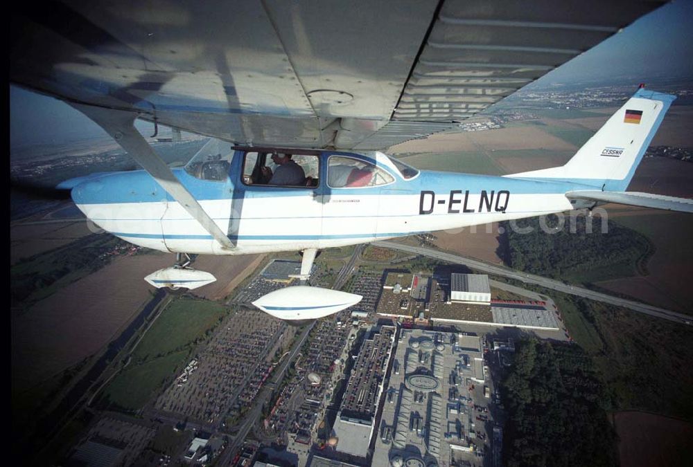 Günthersdorf from above - Bannerschleppflugzeug Cessna 172 D-ELNQ über dem Einkaufszentrum nova eventis der ECE in Günthersdorf / Sachsen.