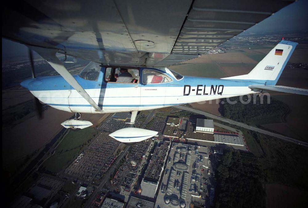 Günthersdorf from the bird's eye view: Bannerschleppflugzeug Cessna 172 D-ELNQ über dem Einkaufszentrum nova eventis der ECE in Günthersdorf / Sachsen.