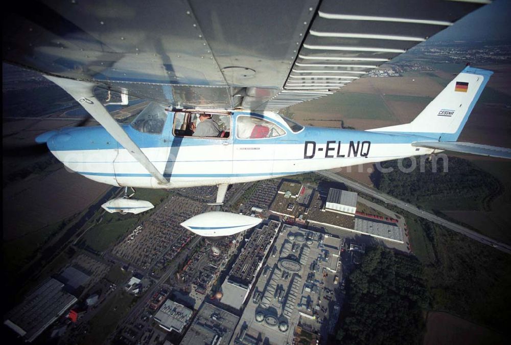 Aerial image Günthersdorf - Bannerschleppflugzeug Cessna 172 D-ELNQ über dem Einkaufszentrum nova eventis der ECE in Günthersdorf / Sachsen.