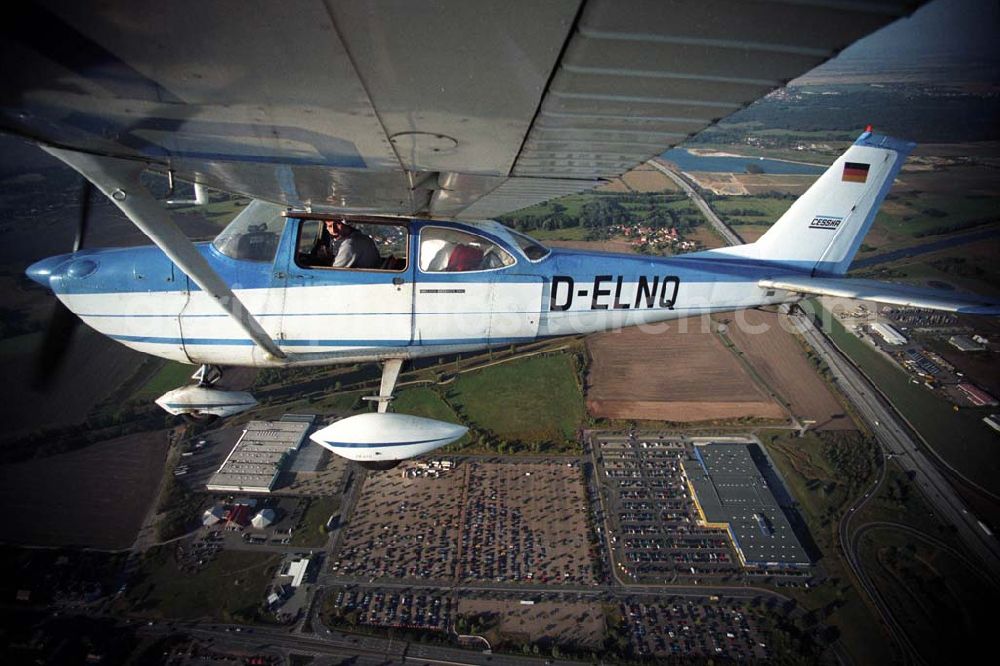 Günthersdorf from above - Bannerschleppflugzeug Cessna 172 D-ELNQ über dem Einkaufszentrum nova eventis der ECE in Günthersdorf / Sachsen.