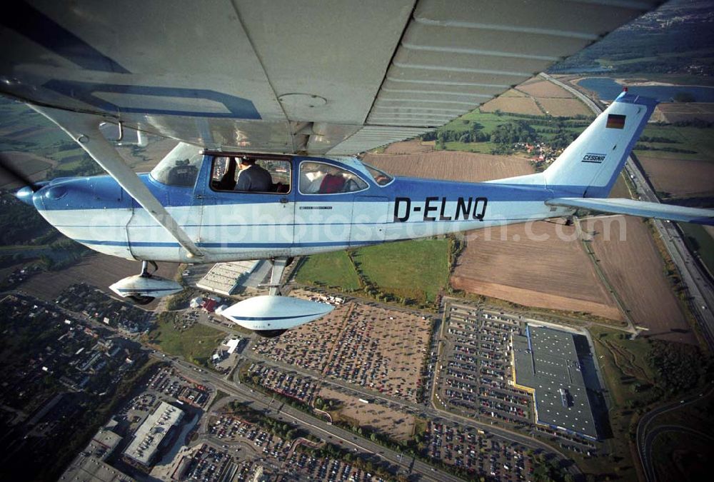 Günthersdorf from the bird's eye view: Bannerschleppflugzeug Cessna 172 D-ELNQ über dem Einkaufszentrum nova eventis der ECE in Günthersdorf / Sachsen.