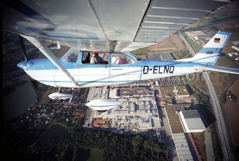 Aerial image Günthersdorf - Bannerschleppflugzeug Cessna 172 D-ELNQ über dem Einkaufszentrum nova eventis der ECE in Günthersdorf / Sachsen.