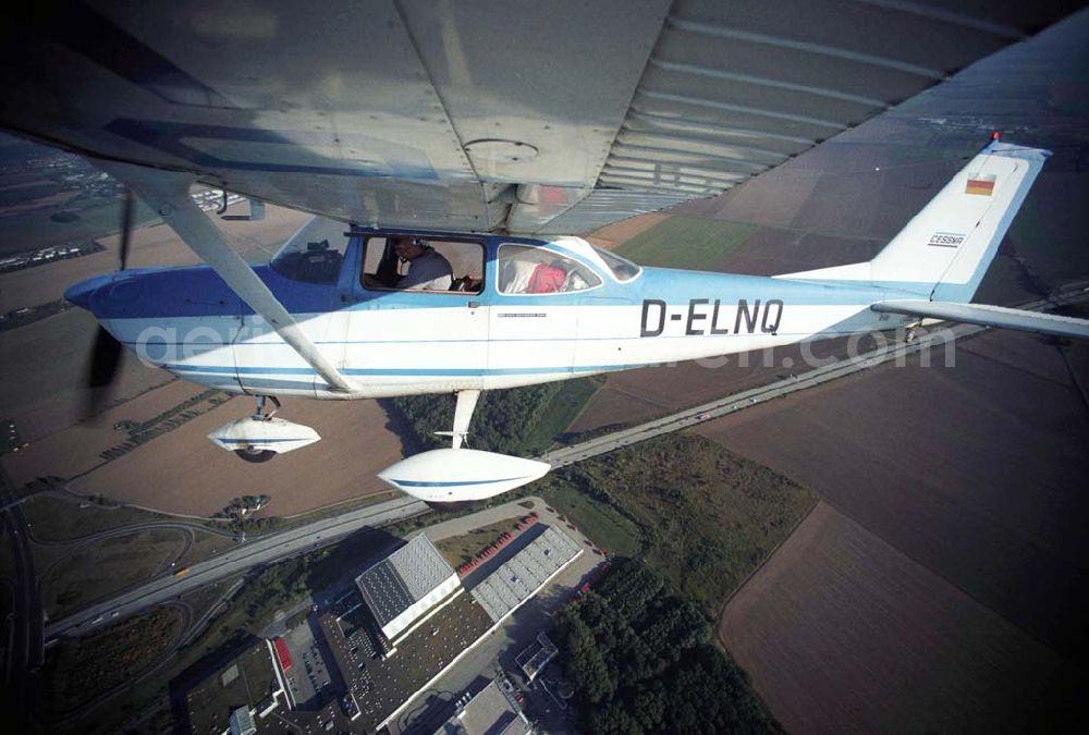 Günthersdorf from the bird's eye view: Bannerschleppflugzeug Cessna 172 D-ELNQ über dem Einkaufszentrum nova eventis der ECE in Günthersdorf / Sachsen.