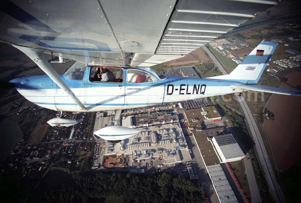 Günthersdorf from above - Bannerschleppflugzeug Cessna 172 D-ELNQ über dem Einkaufszentrum nova eventis der ECE in Günthersdorf / Sachsen.