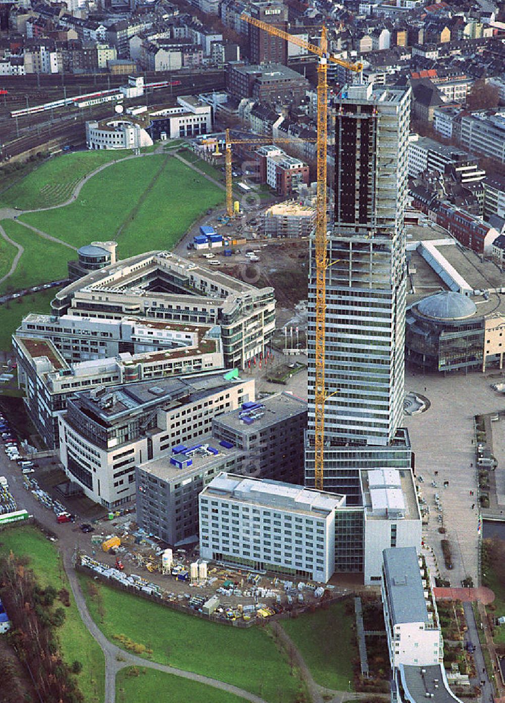 Aerial photograph Köln - Blick auf den Bau des Hochhauses Kölnturm. Der Kölnturm ist mit 148,5 Metern (165,48 Meter mit Antenne) das höchste Bürogebäude in Köln. Er wurde in zweieinhalb Jahren im Kölner Mediapark gebaut. Der Mediapark (Eigenschreibweise: MediaPark) ist ein Anfang des Jahrtausends fertiggestelltes städtebauliches Projekt der Stadt Köln, um Betriebe und Einrichtungen der Medien- und Kommunikationsbranche zusammen mit kulturellen Einrichtungen sowie Wohnungen anzusiedeln. Der Mediapark befindet sich im Kölner Stadtteil Neustadt-Nord auf dem Gelände des ehemaligen Güterbahnhofs Gereon und umfasst rund 20 Hektar. Construction of the skyscraper tower in Cologne Media Park.