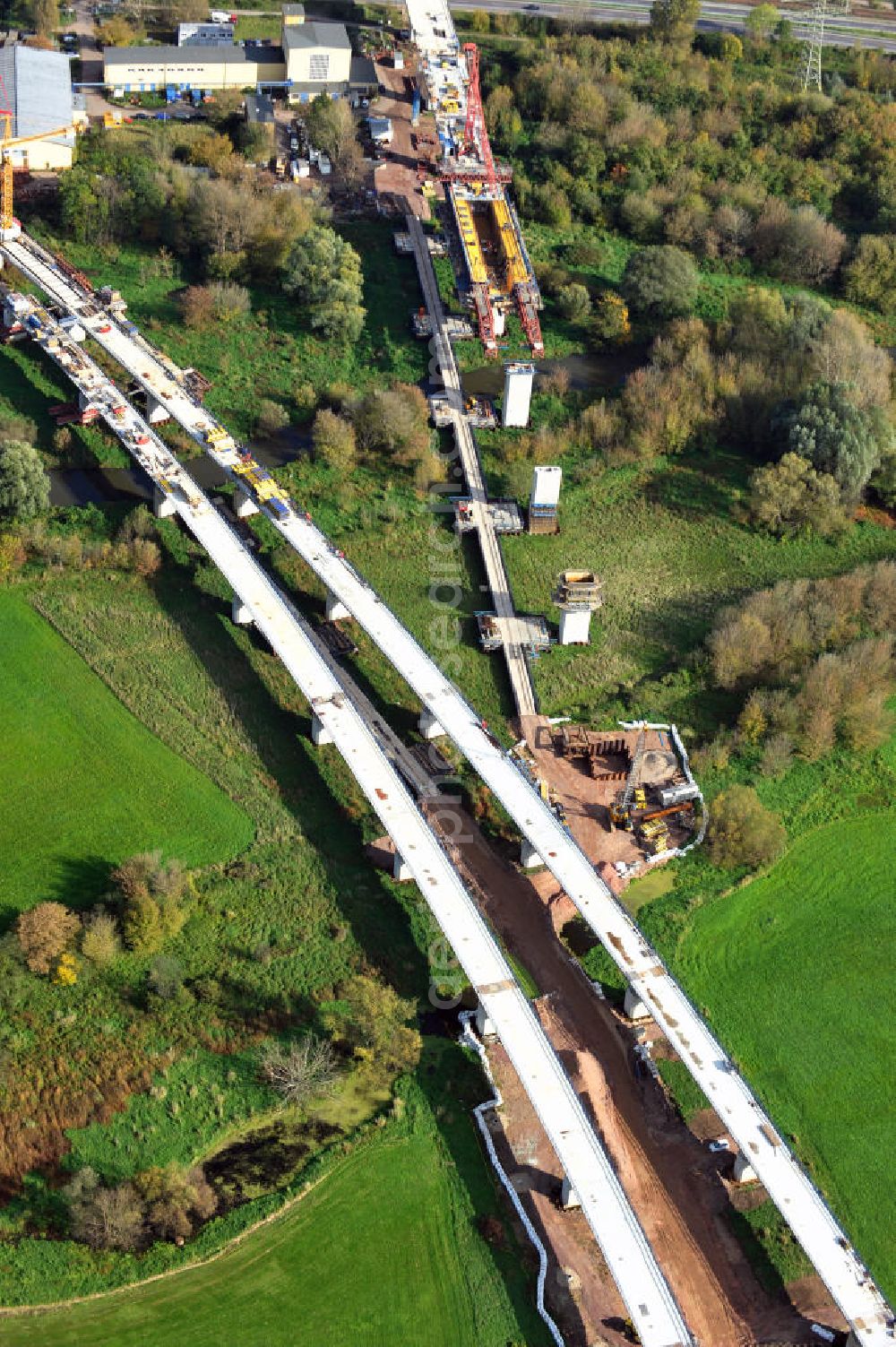 Aerial photograph Rattmannsdorf - Vorschub- Bauarbeiten an der Saale-Elster-Talbrücke zwischen Ammendorf und Schkopau. Das Beton- Viadukt mit insgesamt 8, 5 Kilometern Länge wird teilweise mit großen Baugerüsten in so genannter Vor-Kopf-Bauweise errichtet. Die ICE - Neubaustrecke im Projekt VDE 8 der Deutschen Bahn und der DEGES soll 2015 in Betrieb gehen und wird das bisher längste Brückenbauwerk Deutschlands sein. Bauausführende Firmen sind die Hochtief Construction AG, Adam Hörnig, Gerdum und Breuer; Franki Grundbau; Doka Schalungstechniker; BBV Vorspanntechnik; Röro Traggerüstsysteme; Oevermann Hoch- und Tiefbau, Teupe & Söhne Gerüstbau GmbH, Alpine Bau, Kann Baustoffe und Arcelormittal. Die Bauüberwachung erfolgt durch das Ingenieurbüro Schüßler Plan. Construction site of the Saale-Elster-Talbrücke between Ammendorf and Schkopau. It will be 8, 5 km long and belongs to the Deutsche Bahn project VDE 8 and the DEGES. It should be finished in 2015. Its going to be the longest bridge in Germany. It is constructed by Hochtief Construction AG, Adam Hörnig, Gerdum und Breuer; Franki Grundbau; Doka Schalungstechniker; BBV Vorspanntechnik; Röro Traggerüstsysteme; Oevermann Hoch- und Tiefbau, Teupe & Söhne Gerüstbau GmbH, Alpine Bau, Kann Baustoffe und Arcelormittal.