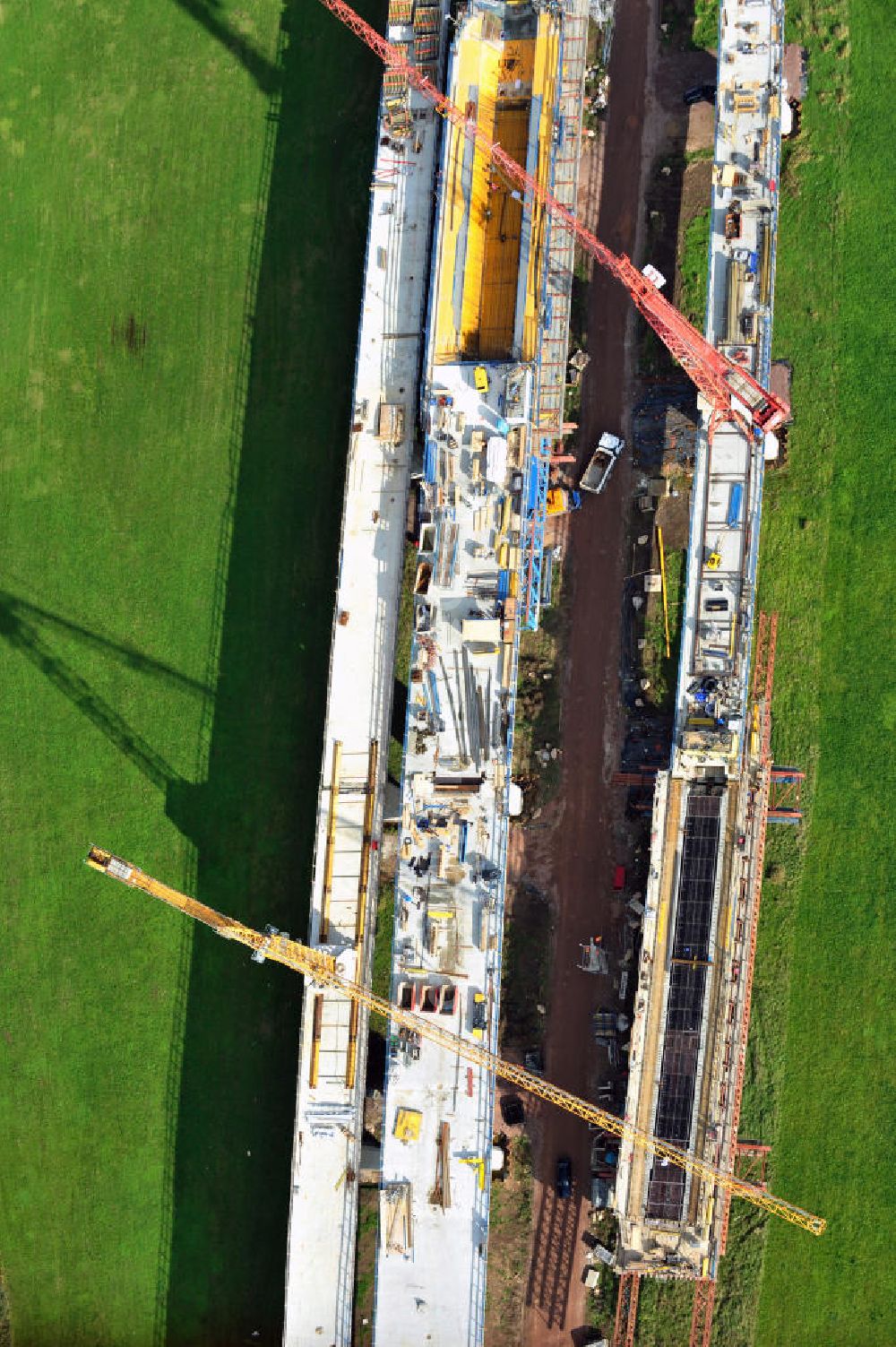 Aerial image Rattmannsdorf - Vorschub- Bauarbeiten an der Saale-Elster-Talbrücke zwischen Ammendorf und Schkopau. Das Beton- Viadukt mit insgesamt 8, 5 Kilometern Länge wird teilweise mit großen Baugerüsten in so genannter Vor-Kopf-Bauweise errichtet. Die ICE - Neubaustrecke im Projekt VDE 8 der Deutschen Bahn und der DEGES soll 2015 in Betrieb gehen und wird das bisher längste Brückenbauwerk Deutschlands sein. Bauausführende Firmen sind die Hochtief Construction AG, Adam Hörnig, Gerdum und Breuer; Franki Grundbau; Doka Schalungstechniker; BBV Vorspanntechnik; Röro Traggerüstsysteme; Oevermann Hoch- und Tiefbau, Teupe & Söhne Gerüstbau GmbH, Alpine Bau, Kann Baustoffe und Arcelormittal. Die Bauüberwachung erfolgt durch das Ingenieurbüro Schüßler Plan. Construction site of the Saale-Elster-Talbrücke between Ammendorf and Schkopau. It will be 8, 5 km long and belongs to the Deutsche Bahn project VDE 8 and the DEGES. It should be finished in 2015. Its going to be the longest bridge in Germany. It is constructed by Hochtief Construction AG, Adam Hörnig, Gerdum und Breuer; Franki Grundbau; Doka Schalungstechniker; BBV Vorspanntechnik; Röro Traggerüstsysteme; Oevermann Hoch- und Tiefbau, Teupe & Söhne Gerüstbau GmbH, Alpine Bau, Kann Baustoffe und Arcelormittal.