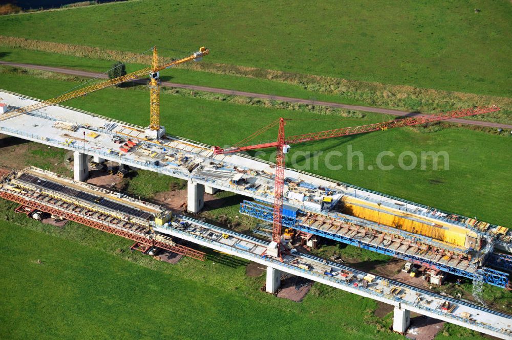 Aerial photograph Rattmannsdorf - Vorschub- Bauarbeiten an der Saale-Elster-Talbrücke zwischen Ammendorf und Schkopau. Das Beton- Viadukt mit insgesamt 8, 5 Kilometern Länge wird teilweise mit großen Baugerüsten in so genannter Vor-Kopf-Bauweise errichtet. Die ICE - Neubaustrecke im Projekt VDE 8 der Deutschen Bahn und der DEGES soll 2015 in Betrieb gehen und wird das bisher längste Brückenbauwerk Deutschlands sein. Bauausführende Firmen sind die Hochtief Construction AG, Adam Hörnig, Gerdum und Breuer; Franki Grundbau; Doka Schalungstechniker; BBV Vorspanntechnik; Röro Traggerüstsysteme; Oevermann Hoch- und Tiefbau, Teupe & Söhne Gerüstbau GmbH, Alpine Bau, Kann Baustoffe und Arcelormittal. Die Bauüberwachung erfolgt durch das Ingenieurbüro Schüßler Plan. Construction site of the Saale-Elster-Talbrücke between Ammendorf and Schkopau. It will be 8, 5 km long and belongs to the Deutsche Bahn project VDE 8 and the DEGES. It should be finished in 2015. Its going to be the longest bridge in Germany. It is constructed by Hochtief Construction AG, Adam Hörnig, Gerdum und Breuer; Franki Grundbau; Doka Schalungstechniker; BBV Vorspanntechnik; Röro Traggerüstsysteme; Oevermann Hoch- und Tiefbau, Teupe & Söhne Gerüstbau GmbH, Alpine Bau, Kann Baustoffe und Arcelormittal.