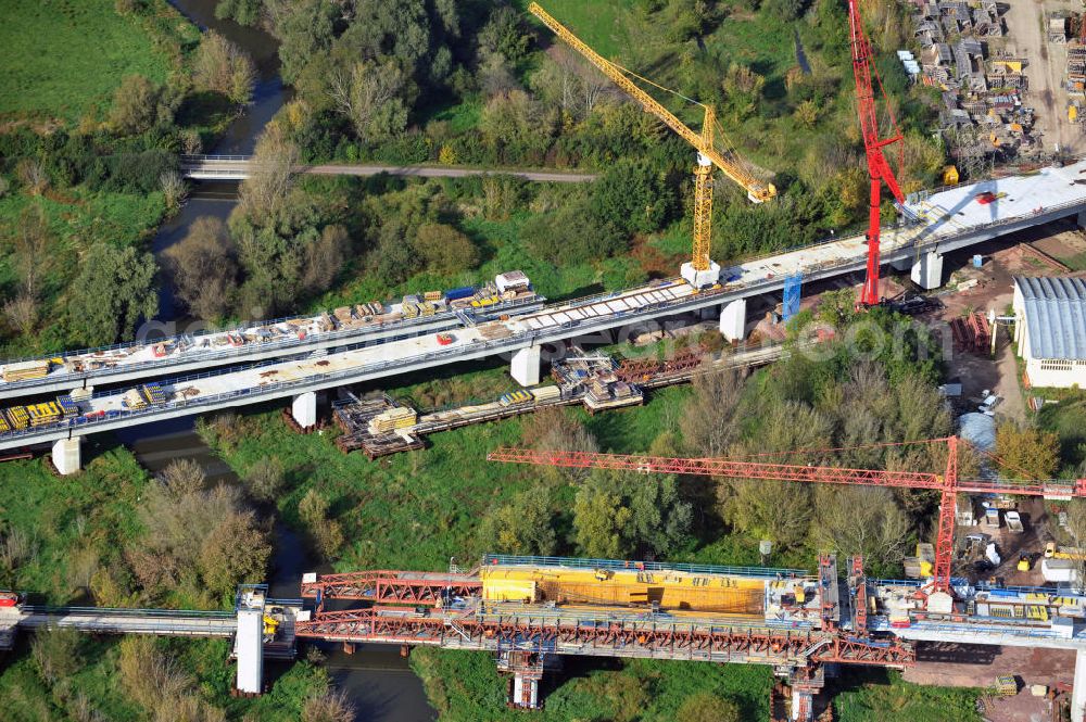 Rattmannsdorf from the bird's eye view: Vorschub- Bauarbeiten an der Saale-Elster-Talbrücke zwischen Ammendorf und Schkopau. Das Beton- Viadukt mit insgesamt 8, 5 Kilometern Länge wird teilweise mit großen Baugerüsten in so genannter Vor-Kopf-Bauweise errichtet. Die ICE - Neubaustrecke im Projekt VDE 8 der Deutschen Bahn und der DEGES soll 2015 in Betrieb gehen und wird das bisher längste Brückenbauwerk Deutschlands sein. Bauausführende Firmen sind die Hochtief Construction AG, Adam Hörnig, Gerdum und Breuer; Franki Grundbau; Doka Schalungstechniker; BBV Vorspanntechnik; Röro Traggerüstsysteme; Oevermann Hoch- und Tiefbau, Teupe & Söhne Gerüstbau GmbH, Alpine Bau, Kann Baustoffe und Arcelormittal. Die Bauüberwachung erfolgt durch das Ingenieurbüro Schüßler Plan. Construction site of the Saale-Elster-Talbrücke between Ammendorf and Schkopau. It will be 8, 5 km long and belongs to the Deutsche Bahn project VDE 8 and the DEGES. It should be finished in 2015. Its going to be the longest bridge in Germany. It is constructed by Hochtief Construction AG, Adam Hörnig, Gerdum und Breuer; Franki Grundbau; Doka Schalungstechniker; BBV Vorspanntechnik; Röro Traggerüstsysteme; Oevermann Hoch- und Tiefbau, Teupe & Söhne Gerüstbau GmbH, Alpine Bau, Kann Baustoffe und Arcelormittal.