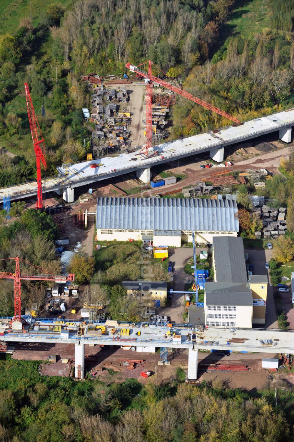 Aerial image Rattmannsdorf - Vorschub- Bauarbeiten an der Saale-Elster-Talbrücke zwischen Ammendorf und Schkopau. Das Beton- Viadukt mit insgesamt 8, 5 Kilometern Länge wird teilweise mit großen Baugerüsten in so genannter Vor-Kopf-Bauweise errichtet. Die ICE - Neubaustrecke im Projekt VDE 8 der Deutschen Bahn und der DEGES soll 2015 in Betrieb gehen und wird das bisher längste Brückenbauwerk Deutschlands sein. Bauausführende Firmen sind die Hochtief Construction AG, Adam Hörnig, Gerdum und Breuer; Franki Grundbau; Doka Schalungstechniker; BBV Vorspanntechnik; Röro Traggerüstsysteme; Oevermann Hoch- und Tiefbau, Teupe & Söhne Gerüstbau GmbH, Alpine Bau, Kann Baustoffe und Arcelormittal. Die Bauüberwachung erfolgt durch das Ingenieurbüro Schüßler Plan. Construction site of the Saale-Elster-Talbrücke between Ammendorf and Schkopau. It will be 8, 5 km long and belongs to the Deutsche Bahn project VDE 8 and the DEGES. It should be finished in 2015. Its going to be the longest bridge in Germany. It is constructed by Hochtief Construction AG, Adam Hörnig, Gerdum und Breuer; Franki Grundbau; Doka Schalungstechniker; BBV Vorspanntechnik; Röro Traggerüstsysteme; Oevermann Hoch- und Tiefbau, Teupe & Söhne Gerüstbau GmbH, Alpine Bau, Kann Baustoffe und Arcelormittal.