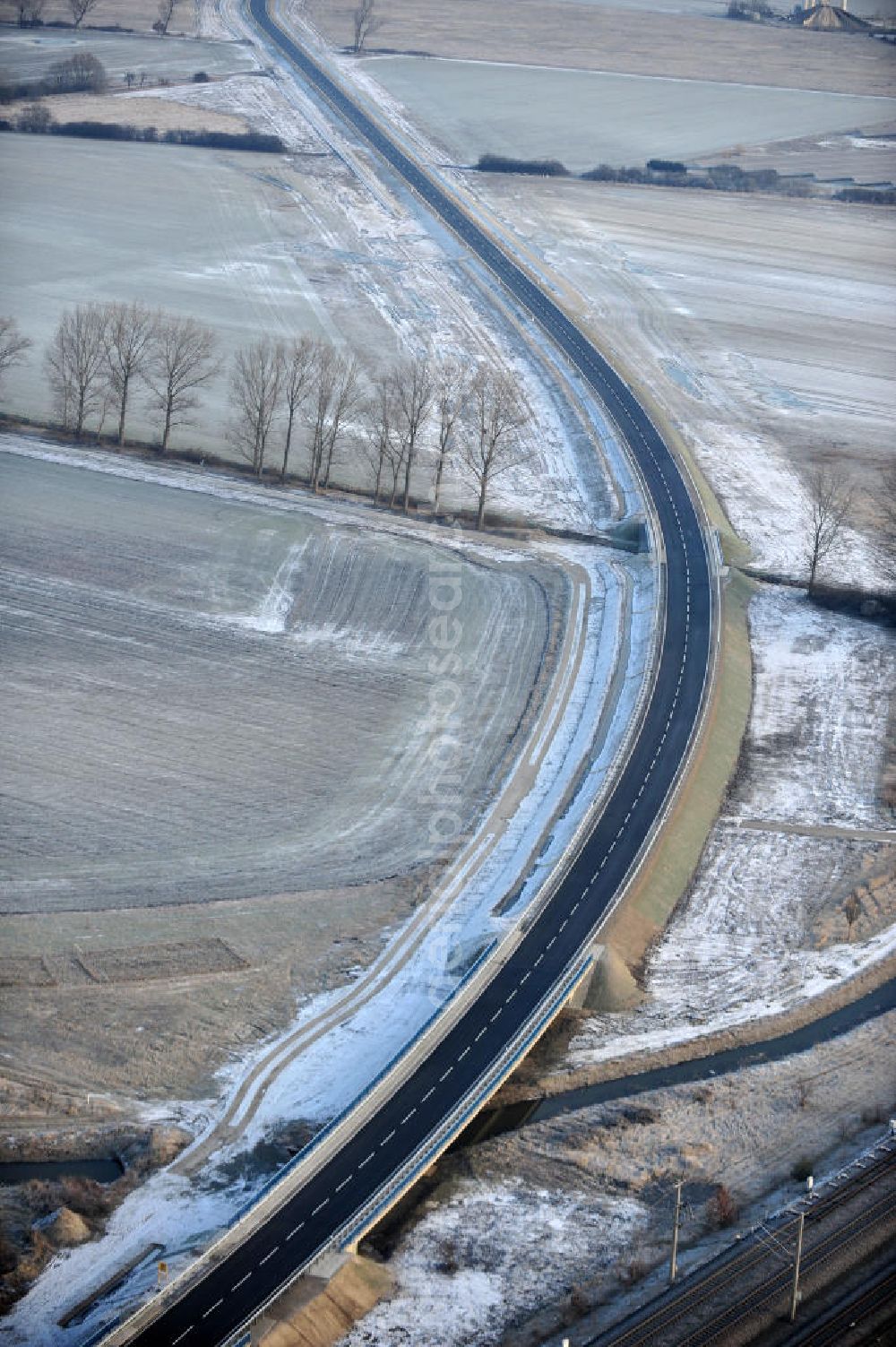 Aerial image Oebisfelde - Winterlich verschneite Neubaustrecken und Brückenbauwerke der neuen Ortsumgehung Oebisfelde - errichtet durch den EUROVIA - Baukonzern in Sachsen-Anhalt. Die Umgehungsstraße der B188 um Oebisfelde ist eine lang diskutierte Entlastung des Innenstadtverkehrs.