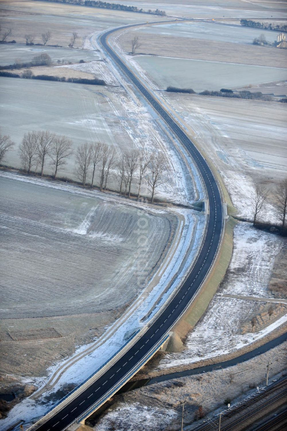 Aerial photograph Oebisfelde - Winterlich verschneite Neubaustrecken und Brückenbauwerke der neuen Ortsumgehung Oebisfelde - errichtet durch den EUROVIA - Baukonzern in Sachsen-Anhalt. Die Umgehungsstraße der B188 um Oebisfelde ist eine lang diskutierte Entlastung des Innenstadtverkehrs.