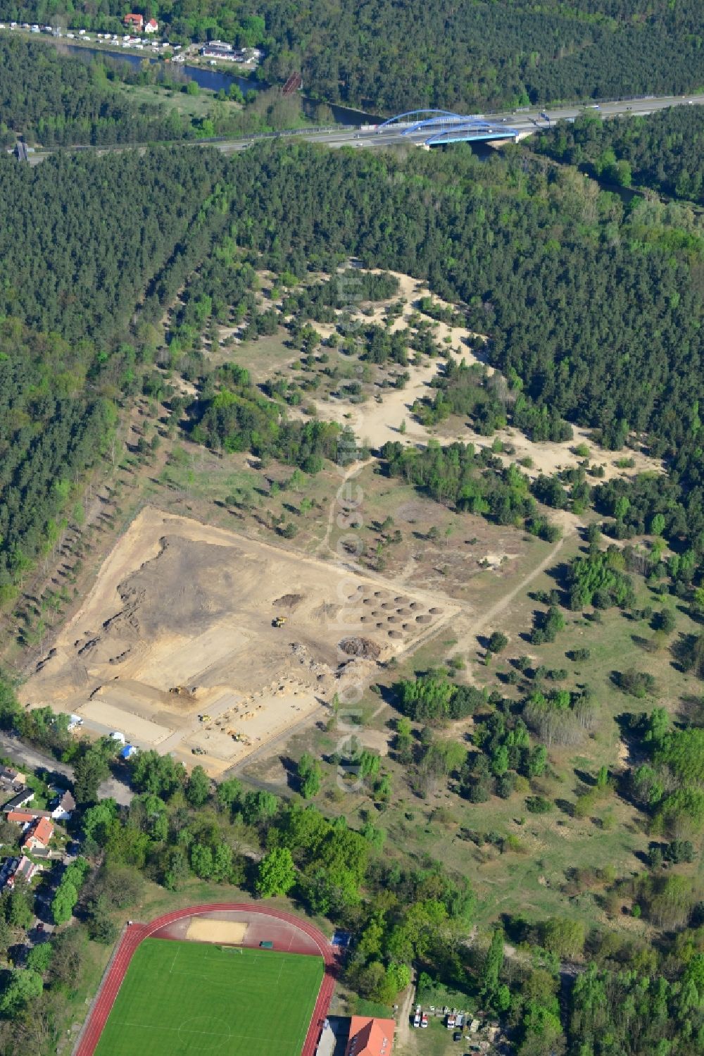 Stahnsdorf from the bird's eye view: Construction works on the Kanalaue Region in Stahnsdorf in the state Brandenburg. The landscape is being developed as a tourism and green region. Several machines and vehicles are working on the open sandy area which is surrounded by forest