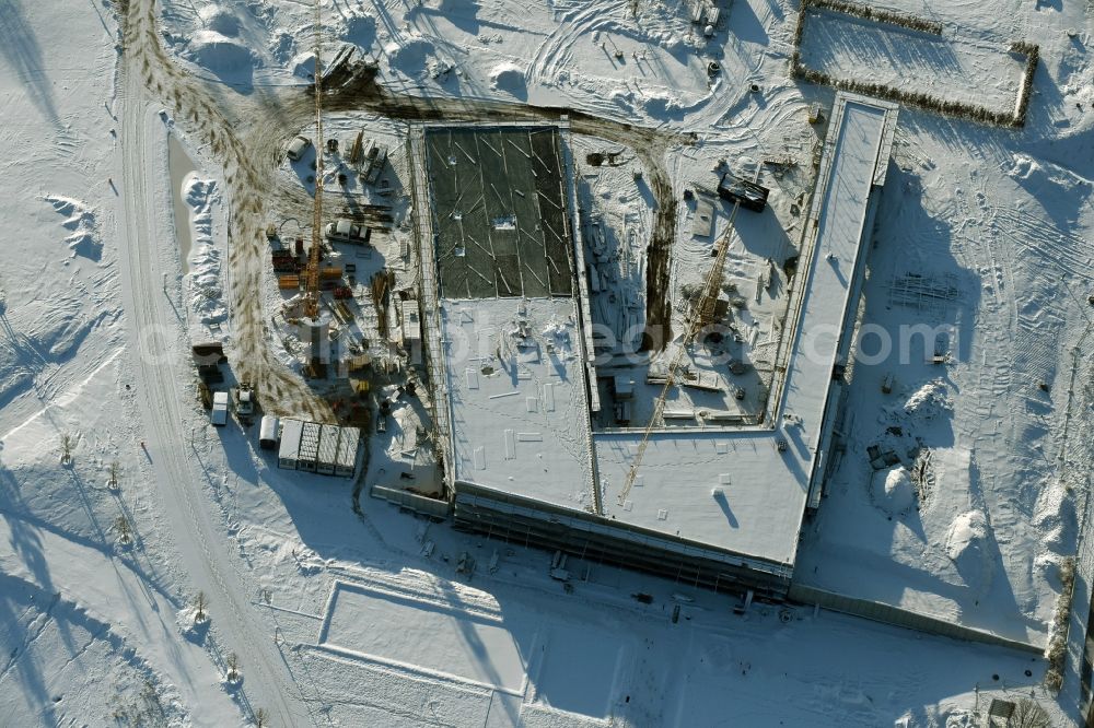 Berlin from above - Wintry snowy construction work for the visitor's centre at the main entrance of the IGA 2017 in the district of Marzahn-Hellersdorf in Berlin. The heart of the International gerden exibition will be the Gaerten der Welt. The visitor's centre is being built near the main entrance on Blumberger Damm