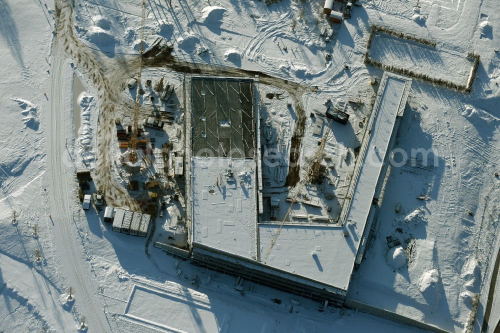 Berlin from the bird's eye view: Wintry snowy construction work for the visitor's centre at the main entrance of the IGA 2017 in the district of Marzahn-Hellersdorf in Berlin. The heart of the International gerden exibition will be the Gaerten der Welt. The visitor's centre is being built near the main entrance on Blumberger Damm