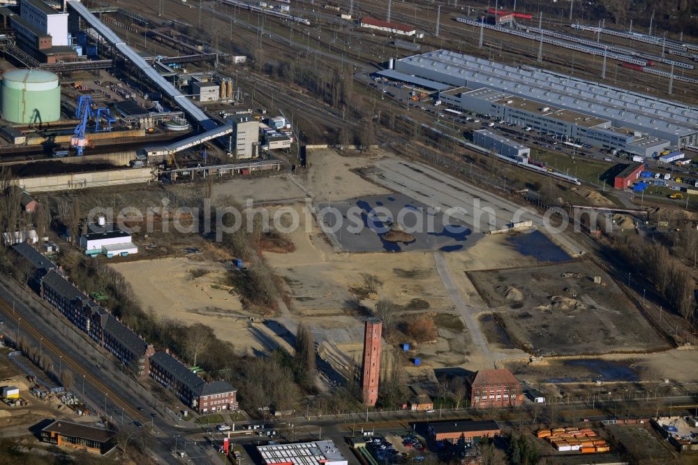 Berlin from above - The broke surface at the Klingenberg power plant in Berlin-Rummelsburg extends at an angle of Koepenick Chaussee and the Blockdammweg. The listed water tower stands in the foreground. In the background the halls of the ICE facility Rummelsburg can be seen