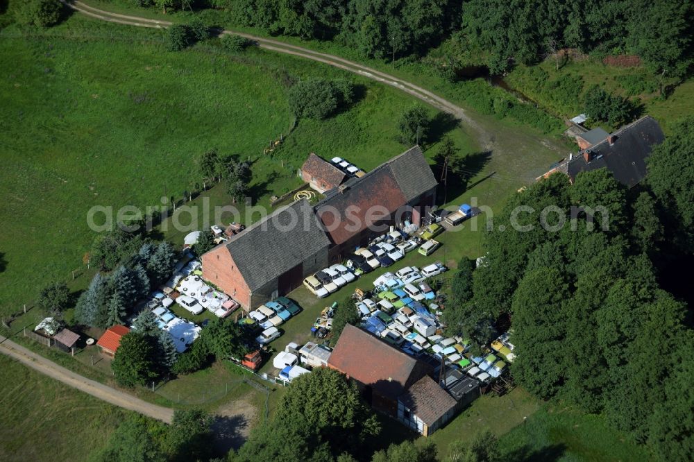 Gräfenhainichen from above - Farm in the North of the Tornau part of the town of Graefenhainichen in the state of Saxony-Anhalt. The agricultural estate is located at a forest and surrounded by meadows. Several cars of the Trabant brand or Trabi are located on the compound