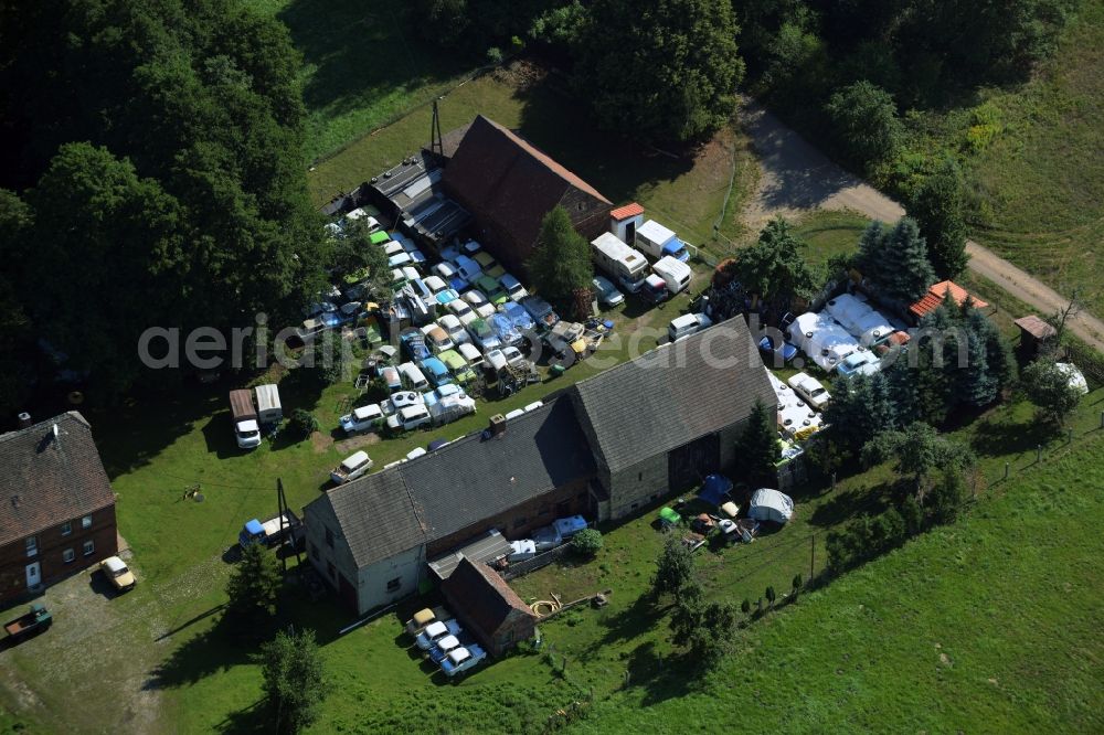 Gräfenhainichen from above - Farm in the North of the Tornau part of the town of Graefenhainichen in the state of Saxony-Anhalt. The agricultural estate is located at a forest and surrounded by meadows. Several cars of the Trabant brand or Trabi are located on the compound