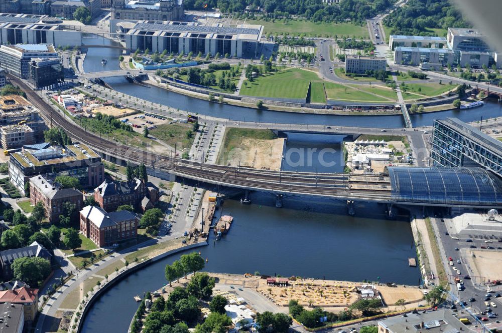 Berlin Mitte from above - Blick auf die Baufelder am Berliner Humboldthafen, eines Spree mit dem Spandauer Schiffahrtskanal verbindenden Hafenbeckens. Er wird begrenzt vom Friedrich-List-Ufer im Westen, vom Alexan derufer im Osten, von der Invalidenstraße im Norden und von der Humboldthafenbrücke im Süden. Östlich schließt sich das Areal des Berliner Universitätsklinikums Charité an, im Westen soll in den nächsten Jahren das „Lehrter Stadtquartier“ genannte Bahnhofsviertel entstehen, dessen Planungen auch eine direkte Hafenrandbebauung miteinschließen. Historisch bedingt durch die Lage im ehemaligen Verlauf an der Berliner Mauer, wird das Areal durch den landeseigenen Immobiliendienstleister Liegenschaftsfonds Berlin vermarktet. Construction site at the Berlin Humboldt Port.