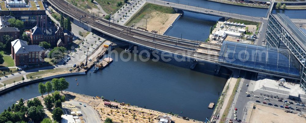 Berlin Mitte from the bird's eye view: Blick auf die Baufelder am Berliner Humboldthafen, eines Spree mit dem Spandauer Schiffahrtskanal verbindenden Hafenbeckens. Er wird begrenzt vom Friedrich-List-Ufer im Westen, vom Alexan derufer im Osten, von der Invalidenstraße im Norden und von der Humboldthafenbrücke im Süden. Östlich schließt sich das Areal des Berliner Universitätsklinikums Charité an, im Westen soll in den nächsten Jahren das „Lehrter Stadtquartier“ genannte Bahnhofsviertel entstehen, dessen Planungen auch eine direkte Hafenrandbebauung miteinschließen. Historisch bedingt durch die Lage im ehemaligen Verlauf an der Berliner Mauer, wird das Areal durch den landeseigenen Immobiliendienstleister Liegenschaftsfonds Berlin vermarktet. Construction site at the Berlin Humboldt Port.