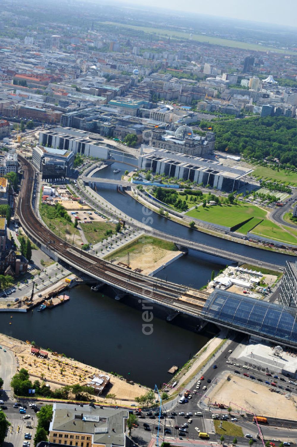 Aerial photograph Berlin Mitte - Blick auf die Baufelder am Berliner Humboldthafen, eines Spree mit dem Spandauer Schiffahrtskanal verbindenden Hafenbeckens. Er wird begrenzt vom Friedrich-List-Ufer im Westen, vom Alexan derufer im Osten, von der Invalidenstraße im Norden und von der Humboldthafenbrücke im Süden. Östlich schließt sich das Areal des Berliner Universitätsklinikums Charité an, im Westen soll in den nächsten Jahren das „Lehrter Stadtquartier“ genannte Bahnhofsviertel entstehen, dessen Planungen auch eine direkte Hafenrandbebauung miteinschließen. Historisch bedingt durch die Lage im ehemaligen Verlauf an der Berliner Mauer, wird das Areal durch den landeseigenen Immobiliendienstleister Liegenschaftsfonds Berlin vermarktet. Construction site at the Berlin Humboldt Port.