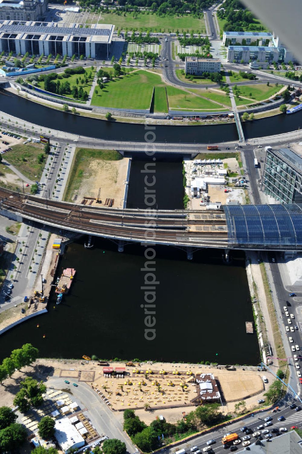 Berlin Mitte from the bird's eye view: Blick auf die Baufelder am Berliner Humboldthafen, eines Spree mit dem Spandauer Schiffahrtskanal verbindenden Hafenbeckens. Er wird begrenzt vom Friedrich-List-Ufer im Westen, vom Alexan derufer im Osten, von der Invalidenstraße im Norden und von der Humboldthafenbrücke im Süden. Östlich schließt sich das Areal des Berliner Universitätsklinikums Charité an, im Westen soll in den nächsten Jahren das „Lehrter Stadtquartier“ genannte Bahnhofsviertel entstehen, dessen Planungen auch eine direkte Hafenrandbebauung miteinschließen. Historisch bedingt durch die Lage im ehemaligen Verlauf an der Berliner Mauer, wird das Areal durch den landeseigenen Immobiliendienstleister Liegenschaftsfonds Berlin vermarktet. Construction site at the Berlin Humboldt Port.