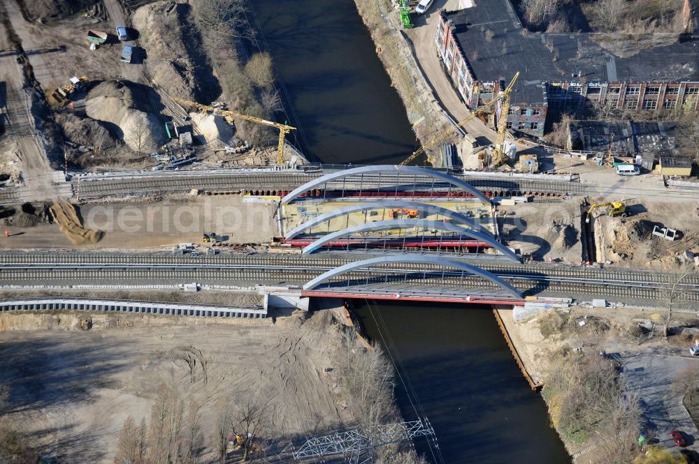 Aerial photograph Berlin-Baumschulenweg - Blick auf den fast fertig umgebauten S-Bahnbrücke über den Kanal zwischen der Glanzstraße / Kiefholzstraße östlich des S-Bahnhof Berlin-Baumschulenweg. Der Um- und Neubau der Brücke ist ein Projekt der EUROVIA Infra GmbH. View onto the construction area at the city railway station in Treptow-Köpenick.