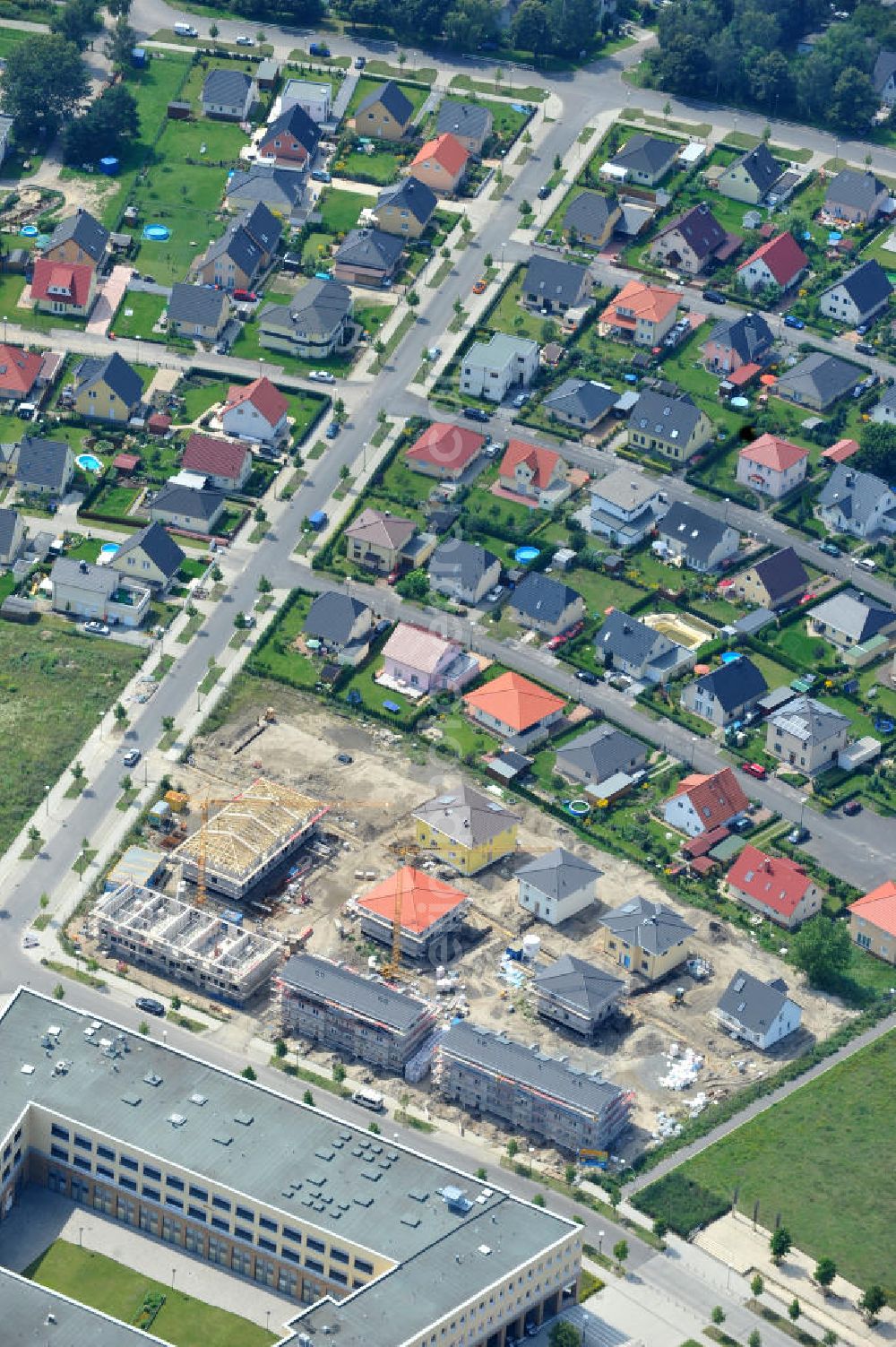 Aerial image Berlin Biesdorf - Blick auf die Baufläche des Wohnneubaus an der Haltoner Straße in Berlin Biesdorf am Elterwerdaer Platz. Die NCC Deutschland GmbH errichet hier ein- und Mehrfamilienhäuser , welche den neuesten Energiesparverordnungen EEWärmeG und EnEV2009 entsprechen. Residential building in Berlin Biesdorf.