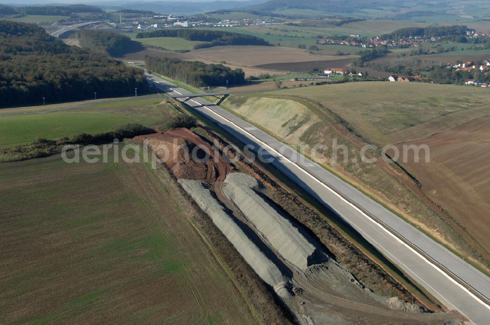 Madelungen from the bird's eye view: Blick über die Baustelle des Autobahnverlaufs A4 aus Richtung Nord-Ost auf die Strassenbrücke zwischen Stregda und Madelungen welche über die A4 führt und den dahinter liegenden Madelungener Forst. Für die Autobahn wurden in diesem Buchen-Wald ca. 12 Hektar Bäume abgeholzt. Der Neubau ist Teil des Projekt Nordverlegung / Umfahrung Hörselberge der Autobahn E40 / A4 in Thüringen bei Eisenach. Durchgeführt werden die im Zuge dieses Projektes notwendigen Arbeiten unter an derem von den Mitarbeitern der Niederlassung Weimar der EUROVIA Verkehrsbau Union sowie der Niederlassungen Abbruch und Erdbau, Betonstraßenbau, Ingenieurbau und TECO Schallschutz der EUROVIA Beton sowie der DEGES.