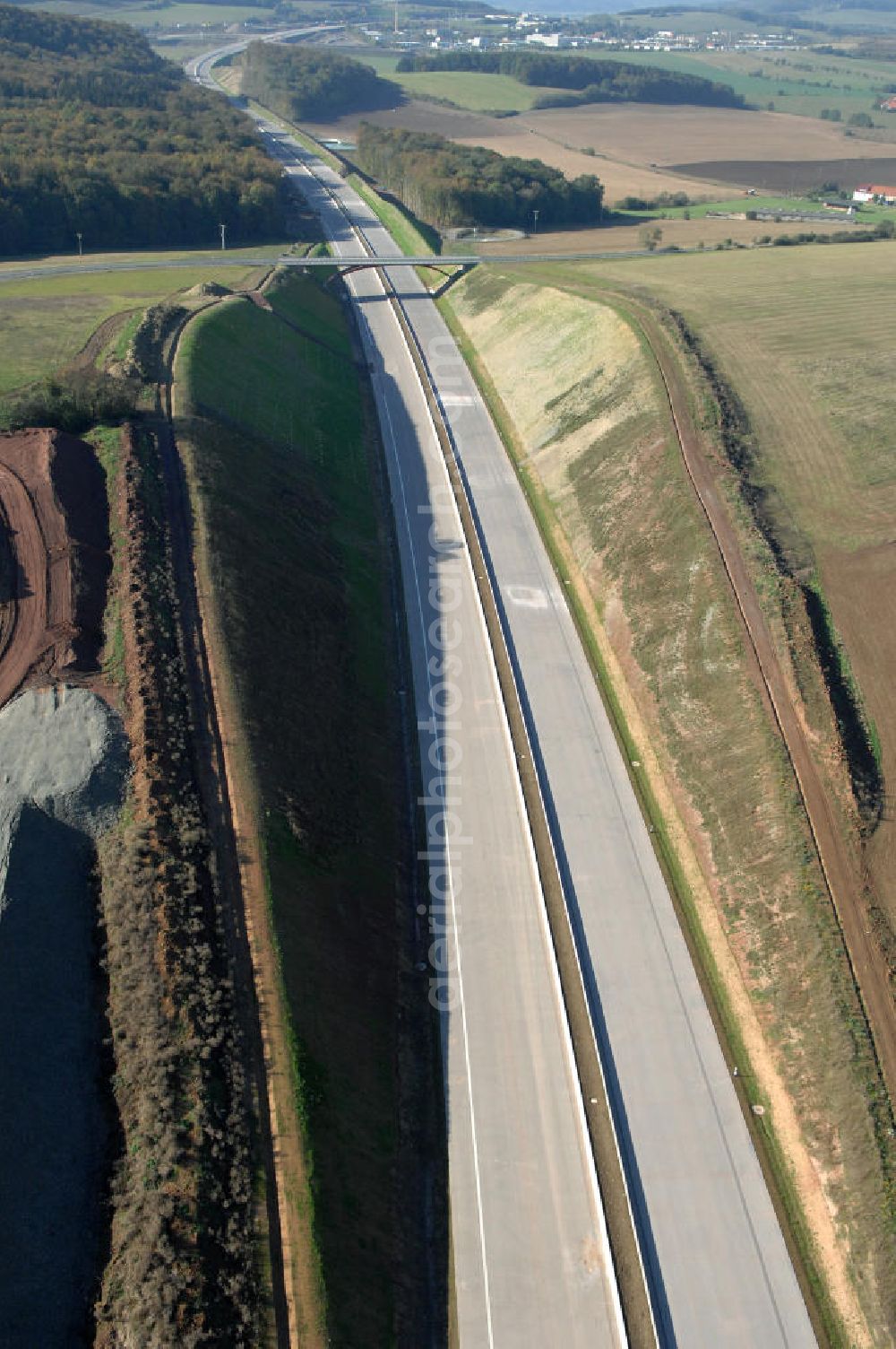 Aerial photograph Madelungen - Blick über die Baustelle des Autobahnverlaufs A4 aus Richtung Nord-Ost auf die Strassenbrücke zwischen Stregda und Madelungen welche über die A4 führt und den dahinter liegenden Madelungener Forst. Für die Autobahn wurden in diesem Buchen-Wald ca. 12 Hektar Bäume abgeholzt. Der Neubau ist Teil des Projekt Nordverlegung / Umfahrung Hörselberge der Autobahn E40 / A4 in Thüringen bei Eisenach. Durchgeführt werden die im Zuge dieses Projektes notwendigen Arbeiten unter an derem von den Mitarbeitern der Niederlassung Weimar der EUROVIA Verkehrsbau Union sowie der Niederlassungen Abbruch und Erdbau, Betonstraßenbau, Ingenieurbau und TECO Schallschutz der EUROVIA Beton sowie der DEGES.