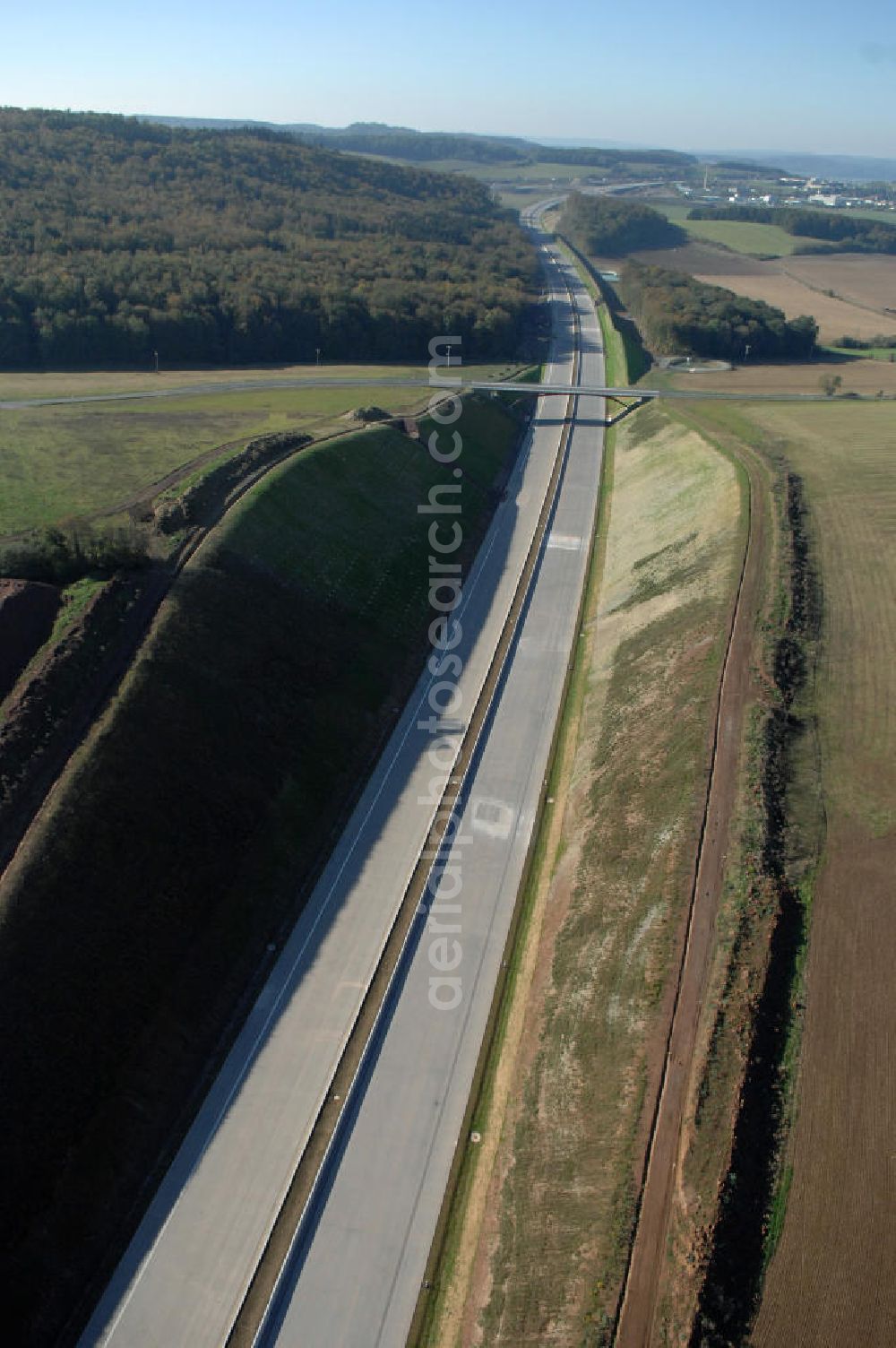 Madelungen from above - Blick über die Baustelle des Autobahnverlaufs A4 aus Richtung Nord-Ost auf die Strassenbrücke zwischen Stregda und Madelungen welche über die A4 führt und den dahinter liegenden Madelungener Forst. Für die Autobahn wurden in diesem Buchen-Wald ca. 12 Hektar Bäume abgeholzt. Der Neubau ist Teil des Projekt Nordverlegung / Umfahrung Hörselberge der Autobahn E40 / A4 in Thüringen bei Eisenach. Durchgeführt werden die im Zuge dieses Projektes notwendigen Arbeiten unter an derem von den Mitarbeitern der Niederlassung Weimar der EUROVIA Verkehrsbau Union sowie der Niederlassungen Abbruch und Erdbau, Betonstraßenbau, Ingenieurbau und TECO Schallschutz der EUROVIA Beton sowie der DEGES.