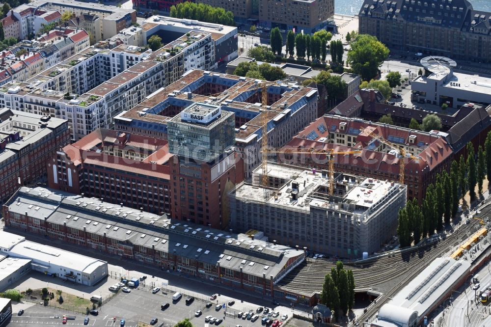 Aerial image Berlin - Construction site on building of the monument protected former Osram respectively Narva company premises Oberbaum City in the district Friedrichshain in Berlin. Here, among many other companies, BASF Services Europe, the German Post Customer Service Center GmbH and Heineken Germany GmbH are located. It is owned by HVB Immobilien AG, which is part of the UniCredit Group