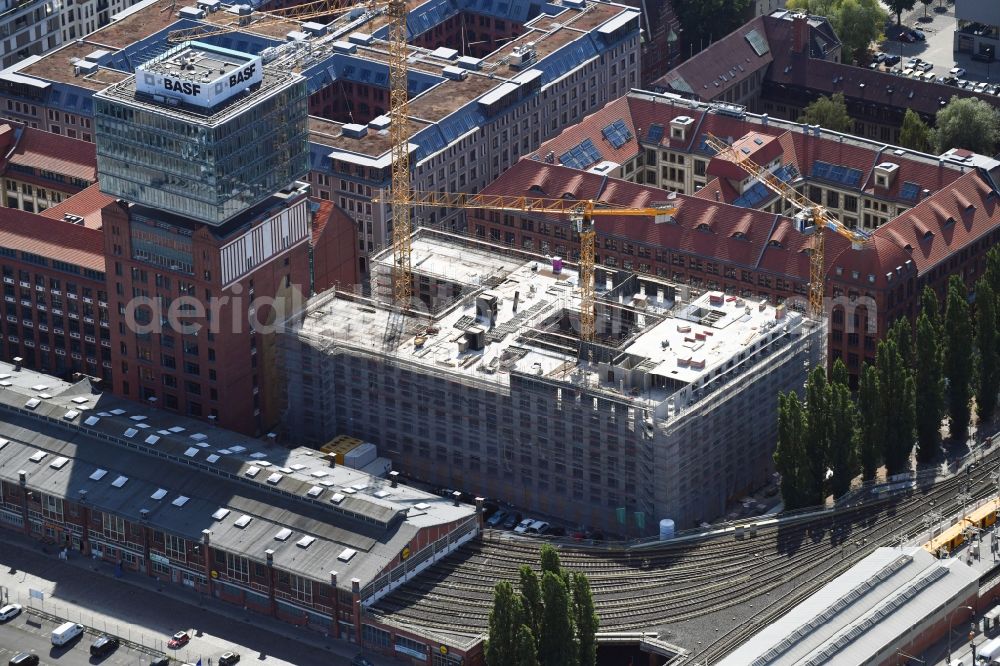 Aerial photograph Berlin - Construction site on building of the monument protected former Osram respectively Narva company premises Oberbaum City in the district Friedrichshain in Berlin. Here, among many other companies, BASF Services Europe, the German Post Customer Service Center GmbH and Heineken Germany GmbH are located. It is owned by HVB Immobilien AG, which is part of the UniCredit Group