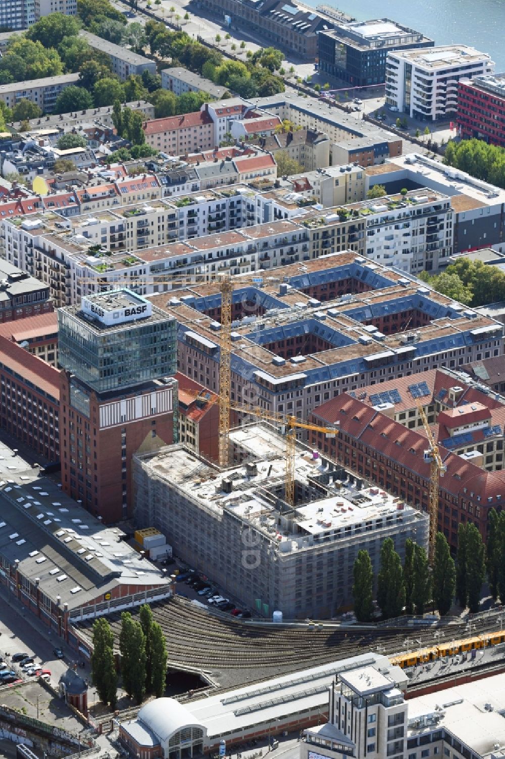 Berlin from the bird's eye view: Construction site on building of the monument protected former Osram respectively Narva company premises Oberbaum City in the district Friedrichshain in Berlin. Here, among many other companies, BASF Services Europe, the German Post Customer Service Center GmbH and Heineken Germany GmbH are located. It is owned by HVB Immobilien AG, which is part of the UniCredit Group