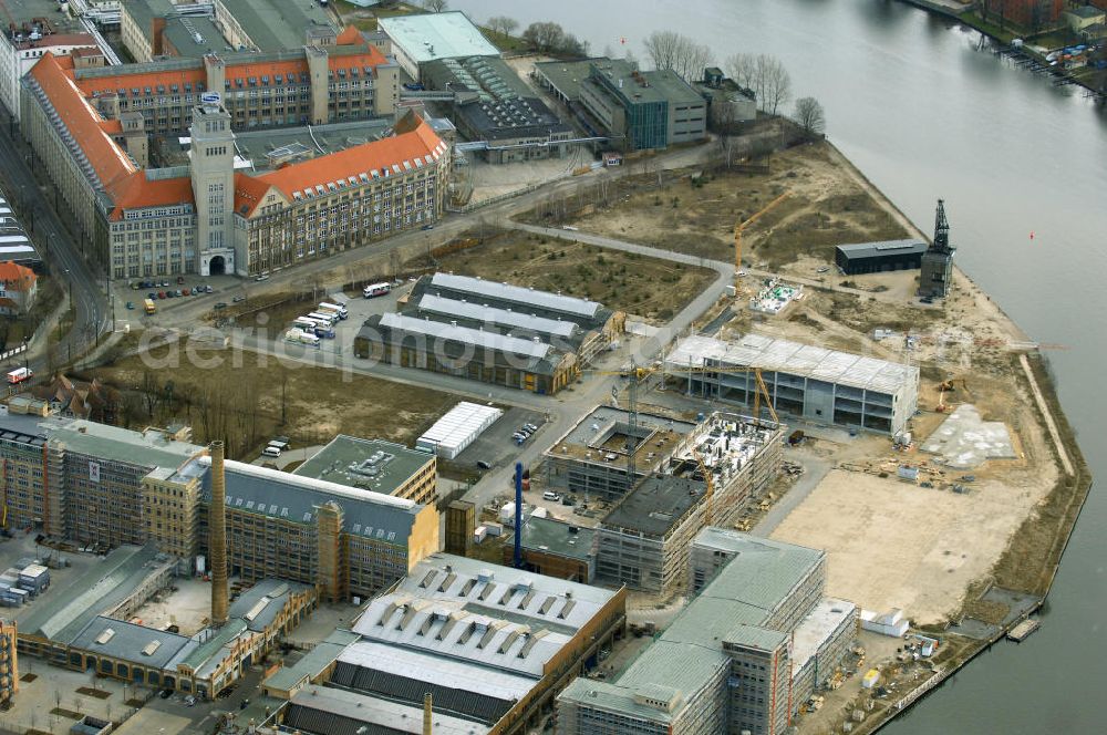 Berlin from the bird's eye view: Blick auf die Bauarbeiten für den neuen Campus der Berliner Fachhochschule für Technik und Wirtschaft (FHTW) an der Wilhelmininhofstrasse 76/77. Bis zum Wintersemester 2009/2010 sollen auf dem direkt an der Spree gelegenen ehemaligen Industrieareal im Südosten Berlins Hörsäle, Labore und Seminarräume, eine großzügige Bibliothek und eine Mensa für rund 6000 Studierende entstehen sowie rund 250 Professoren und Mitarbeiter ihren Arbeitsplatz vorfinden.Insgesamt sind für Um-, Aus- und Neubaumaßnahmen auf dem neuen Campus der FHTW rund vier Jahre veranschlagt. Die Kosten für den Aus- und Umbau der bereits sanierten Industriearchitektur sowie für Neubauten belaufen sich auf insgesamt 108 Millionen Euro. Sie werden je zur Hälfte aus dem Haushalt des Landes und des Bundes finanziert. Ziel der Investitionen ist es, attraktive Bedingungen für Studium, Lehre und Forschung an der größten und vielfältigsten Berliner Fachhochschule zu schaffen. Statt derzeit fünf zum Teil weit voneinan der entfernte Hochschulstandorte wird die FHTW künftig nur noch zwei Standorte in größerer räumlicher Nähe haben: den Campus Oberschöneweide mit 6000 Studierenden und den Campus Karlshorst mit 4000 Studierenden. Die übrigen vier Standorte werden aufgegeben. Ausführende Baufirma ist die WOLFF & MÜLLER GmbH & Co. KG, Schwieberdinger Straße 107,70435 Stuttgart,Telefon +49 711 82 04-0 Telefax +49 711 82 04-3 35,info@wolff-mueller.de