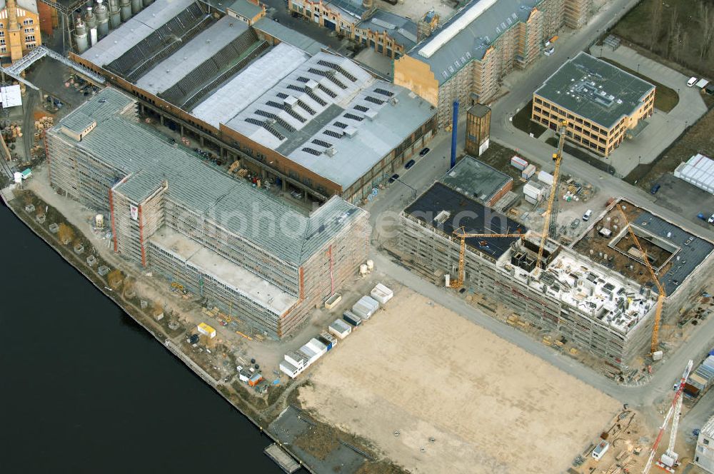 Berlin from the bird's eye view: Blick auf die Bauarbeiten für den neuen Campus der Berliner Fachhochschule für Technik und Wirtschaft (FHTW) an der Wilhelmininhofstrasse 76/77. Bis zum Wintersemester 2009/2010 sollen auf dem direkt an der Spree gelegenen ehemaligen Industrieareal im Südosten Berlins Hörsäle, Labore und Seminarräume, eine großzügige Bibliothek und eine Mensa für rund 6000 Studierende entstehen sowie rund 250 Professoren und Mitarbeiter ihren Arbeitsplatz vorfinden.Insgesamt sind für Um-, Aus- und Neubaumaßnahmen auf dem neuen Campus der FHTW rund vier Jahre veranschlagt. Die Kosten für den Aus- und Umbau der bereits sanierten Industriearchitektur sowie für Neubauten belaufen sich auf insgesamt 108 Millionen Euro. Sie werden je zur Hälfte aus dem Haushalt des Landes und des Bundes finanziert. Ziel der Investitionen ist es, attraktive Bedingungen für Studium, Lehre und Forschung an der größten und vielfältigsten Berliner Fachhochschule zu schaffen. Statt derzeit fünf zum Teil weit voneinan der entfernte Hochschulstandorte wird die FHTW künftig nur noch zwei Standorte in größerer räumlicher Nähe haben: den Campus Oberschöneweide mit 6000 Studierenden und den Campus Karlshorst mit 4000 Studierenden. Die übrigen vier Standorte werden aufgegeben. Ausführende Baufirma ist die WOLFF & MÜLLER GmbH & Co. KG, Schwieberdinger Straße 107,70435 Stuttgart,Telefon +49 711 82 04-0 Telefax +49 711 82 04-3 35,info@wolff-mueller.de