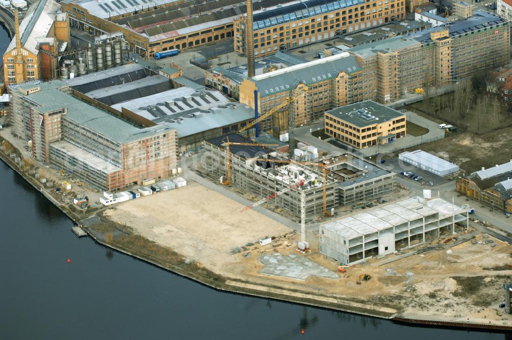 Aerial image Berlin - Blick auf die Bauarbeiten für den neuen Campus der Berliner Fachhochschule für Technik und Wirtschaft (FHTW) an der Wilhelmininhofstrasse 76/77. Bis zum Wintersemester 2009/2010 sollen auf dem direkt an der Spree gelegenen ehemaligen Industrieareal im Südosten Berlins Hörsäle, Labore und Seminarräume, eine großzügige Bibliothek und eine Mensa für rund 6000 Studierende entstehen sowie rund 250 Professoren und Mitarbeiter ihren Arbeitsplatz vorfinden.Insgesamt sind für Um-, Aus- und Neubaumaßnahmen auf dem neuen Campus der FHTW rund vier Jahre veranschlagt. Die Kosten für den Aus- und Umbau der bereits sanierten Industriearchitektur sowie für Neubauten belaufen sich auf insgesamt 108 Millionen Euro. Sie werden je zur Hälfte aus dem Haushalt des Landes und des Bundes finanziert. Ziel der Investitionen ist es, attraktive Bedingungen für Studium, Lehre und Forschung an der größten und vielfältigsten Berliner Fachhochschule zu schaffen. Statt derzeit fünf zum Teil weit voneinan der entfernte Hochschulstandorte wird die FHTW künftig nur noch zwei Standorte in größerer räumlicher Nähe haben: den Campus Oberschöneweide mit 6000 Studierenden und den Campus Karlshorst mit 4000 Studierenden. Die übrigen vier Standorte werden aufgegeben. Ausführende Baufirma ist die WOLFF & MÜLLER GmbH & Co. KG, Schwieberdinger Straße 107,70435 Stuttgart,Telefon +49 711 82 04-0 Telefax +49 711 82 04-3 35,info@wolff-mueller.de