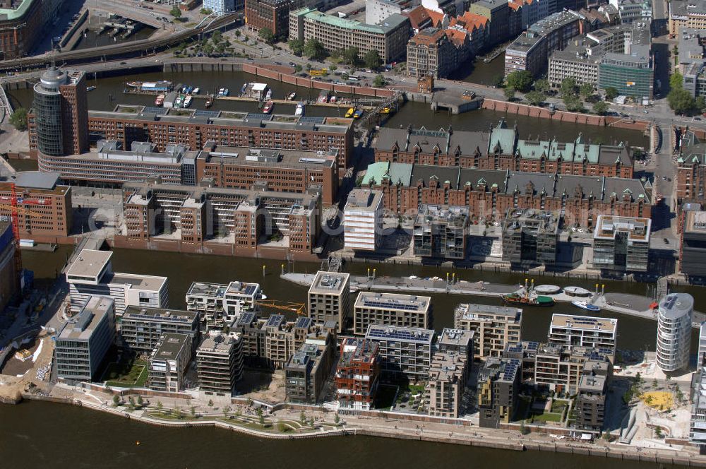 Aerial image Hamburg - Blick auf die Baustelle der neu entstehenden Hafen City. Im Vordergrund der Dalmannkai mit den Projekten / Gebäuden 9-13 und 20-23 und im Hintergrund die Gebäude 1-8 Am Sandtorkai, sowie ein Teil der Speicherstadt. Die HafenCity ist ein Hamburger Stadtteil im Bezirk Hamburg-Mitte. Der 155 Hektar große Stadtteil (mit 60 Hektar Nettobauland) soll neben Büroflächen für mehr als 40.000 Arbeitsplätze, die zu einem Teil schon fertiggestellt sind, auch Wohnraum für 12.000 Einwohner in 5.500 Wohnungen bieten und ist damit das größte laufende Vorhaben zur Stadtentwicklung von Hamburg. Allgemeine Informationen: