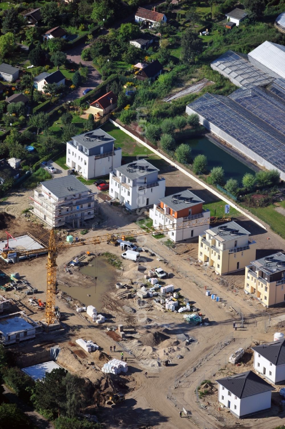 Aerial photograph Berlin - View at the construction site of duplex and single-family house new buildings with solar system near the Britzer Garden in the district Britz in Berlin. The developer NCC Germany GmbH built here a family-friendly residential complex of three different types of houses