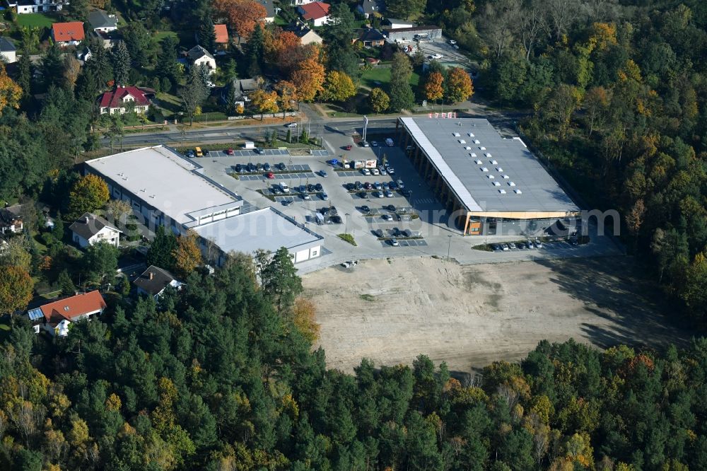 Aerial photograph Hohen Neuendorf - Construction site of a new shopping center and store of the Supermarket REWE in Hohen Neuendorf in the state of Brandenburg. A new shopping facility with stores is being built as part of the regeneration of the shopping center HDZ on Schoenfliesser Strasse. The project is carried out by GVG Projektentwicklungsgesellschaft mbH