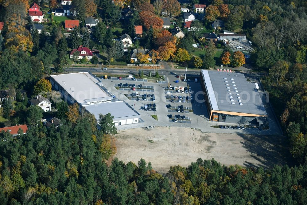 Hohen Neuendorf from above - Construction site of a new shopping center and store of the Supermarket REWE in Hohen Neuendorf in the state of Brandenburg. A new shopping facility with stores is being built as part of the regeneration of the shopping center HDZ on Schoenfliesser Strasse. The project is carried out by GVG Projektentwicklungsgesellschaft mbH