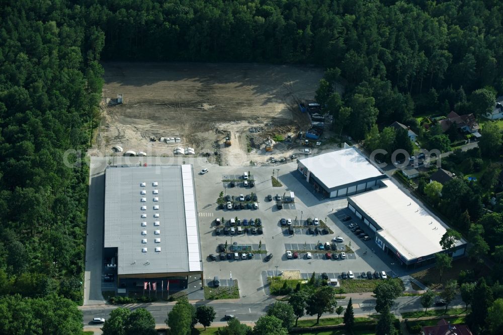 Aerial photograph Hohen Neuendorf - Construction site of a new shopping center and store of the Supermarket REWE in Hohen Neuendorf in the state of Brandenburg. A new shopping facility with stores is being built as part of the regeneration of the shopping center HDZ on Schoenfliesser Strasse. The project is carried out by GVG Projektentwicklungsgesellschaft mbH