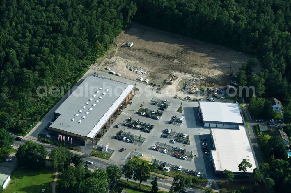 Hohen Neuendorf from above - Construction site of a new shopping center and store of the Supermarket REWE in Hohen Neuendorf in the state of Brandenburg. A new shopping facility with stores is being built as part of the regeneration of the shopping center HDZ on Schoenfliesser Strasse. The project is carried out by GVG Projektentwicklungsgesellschaft mbH