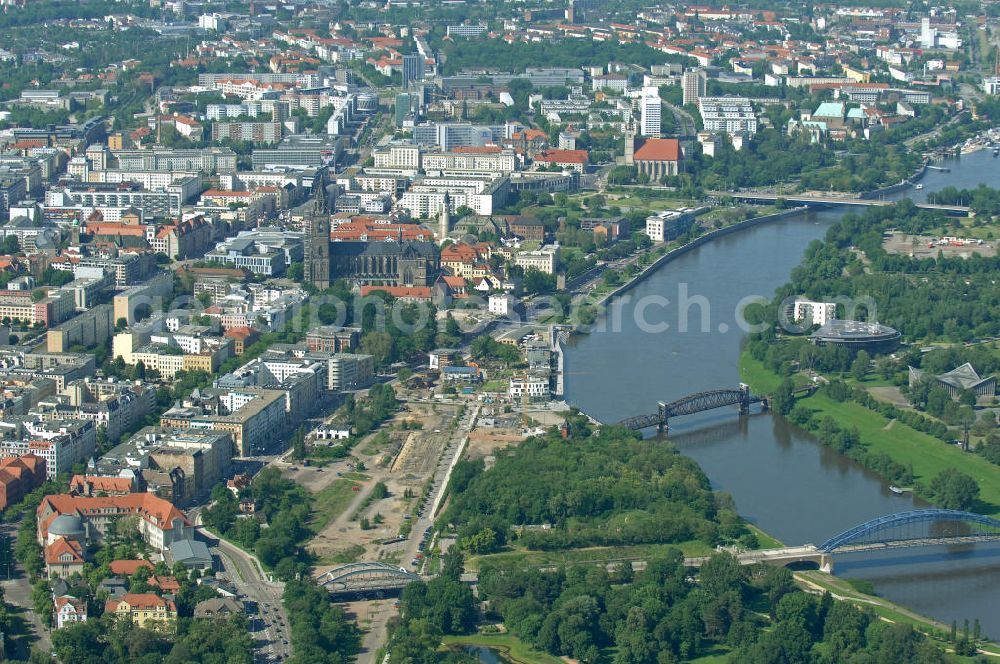 Magdeburg from the bird's eye view: Baustelle am Elbebahnhof in Magdeburg, Sachsen-Anhalt. Die Baustelle ist ein Bauprojekt der WAF GmbH. Es entstehen Eigentumswohnungen und Stadthäuser. Die Brücke ist ein Teil der Sternbrücke. Weiter zu sehen ist der Magdeburger Dom, welcher das älteste gotische Bauwerk auf deutschen Boden ist. Construction site on the Elbe-station in Magdeburg, Saxony-Anhalt. The construction site is a development of the WAF GmbH emerge condominiums and townhouses.The bridge is a part of the star bridge. Next to see the Cathedral of Magdeburg, which is the oldest Gothic building on German soil.