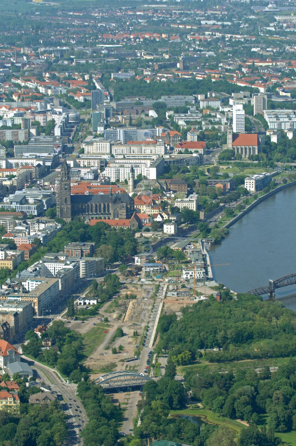 Magdeburg from the bird's eye view: Baustelle am Elbebahnhof in Magdeburg, Sachsen-Anhalt. Die Baustelle ist ein Bauprojekt der WAF GmbH. Es entstehen Eigentumswohnungen und Stadthäuser. Die Brücke ist ein Teil der Sternbrücke. Weiter zu sehen ist der Magdeburger Dom, welcher das älteste gotische Bauwerk auf deutschen Boden ist. Construction site on the Elbe-station in Magdeburg, Saxony-Anhalt. The construction site is a development of the WAF GmbH emerge condominiums and townhouses.The bridge is a part of the star bridge. Next to see the Cathedral of Magdeburg, which is the oldest Gothic building on German soil.