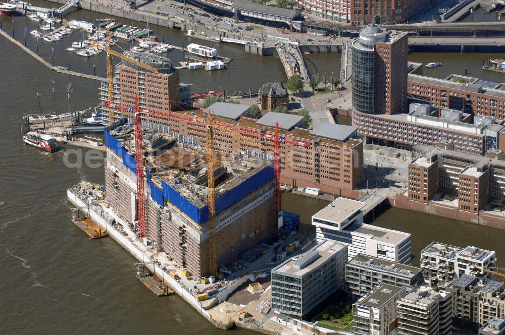 Hamburg from above - Blick auf die Baustelle der Elbphilharmonie auf dem Kaispeicher A der neu entstehenden Hafen City. Die HafenCity ist ein Hamburger Stadtteil im Bezirk Hamburg-Mitte. Der 155 Hektar große Stadtteil (mit 60 Hektar Nettobauland) soll neben Büroflächen für mehr als 40.000 Arbeitsplätze, die zu einem Teil schon fertiggestellt sind, auch Wohnraum für 12.000 Einwohner in 5.500 Wohnungen bieten und ist damit das größte laufende Vorhaben zur Stadtentwicklung von Hamburg. Allgemeine Informationen: