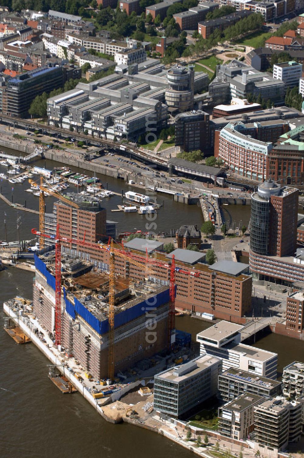 Hamburg from the bird's eye view: Blick auf die Baustelle der Elbphilharmonie auf dem Kaispeicher A der neu entstehenden Hafen City. Die HafenCity ist ein Hamburger Stadtteil im Bezirk Hamburg-Mitte. Der 155 Hektar große Stadtteil (mit 60 Hektar Nettobauland) soll neben Büroflächen für mehr als 40.000 Arbeitsplätze, die zu einem Teil schon fertiggestellt sind, auch Wohnraum für 12.000 Einwohner in 5.500 Wohnungen bieten und ist damit das größte laufende Vorhaben zur Stadtentwicklung von Hamburg. Allgemeine Informationen: